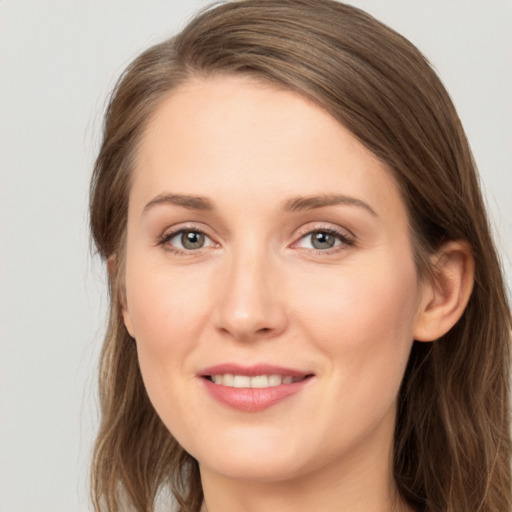 Joyful white young-adult female with long  brown hair and grey eyes