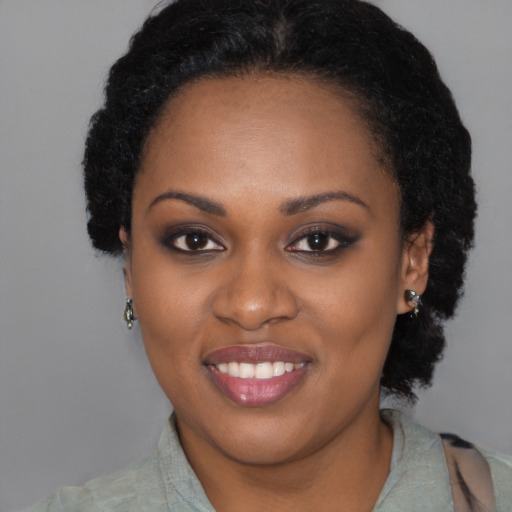 Joyful black young-adult female with long  brown hair and brown eyes