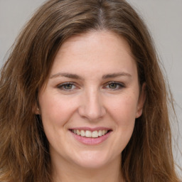 Joyful white young-adult female with long  brown hair and green eyes