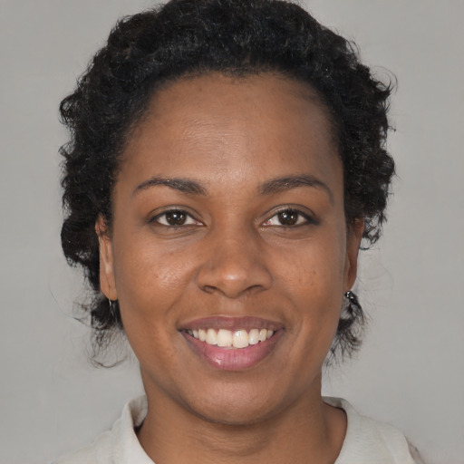 Joyful black young-adult female with medium  brown hair and brown eyes