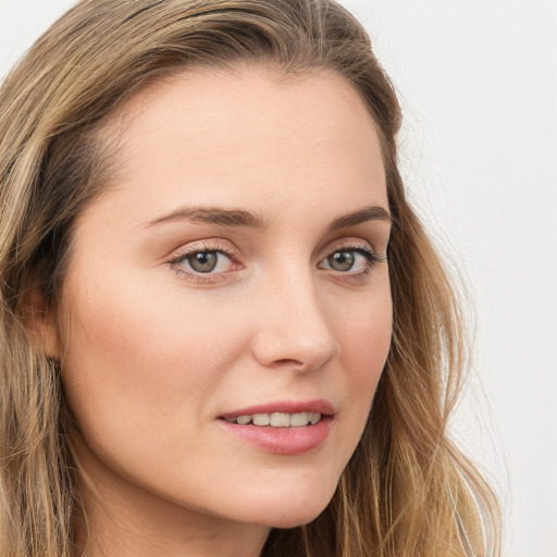 Joyful white young-adult female with long  brown hair and blue eyes