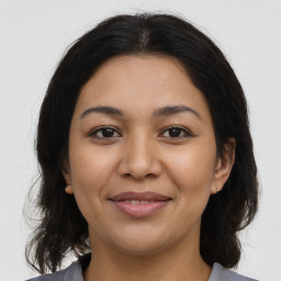 Joyful latino young-adult female with medium  brown hair and brown eyes