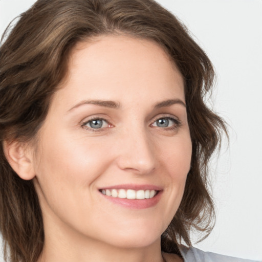 Joyful white young-adult female with medium  brown hair and grey eyes