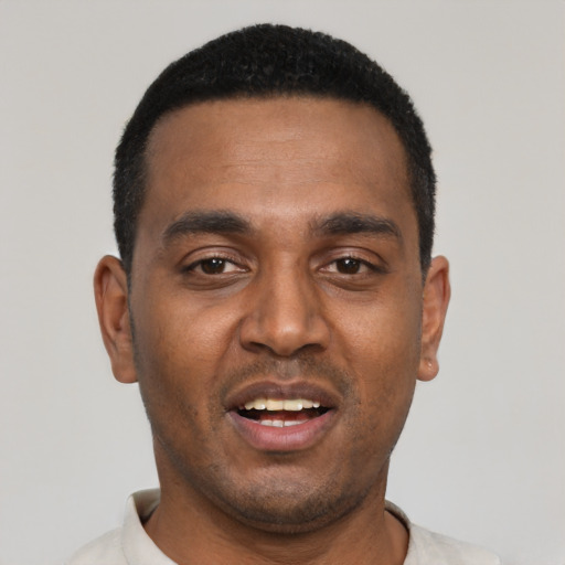Joyful black young-adult male with short  black hair and brown eyes