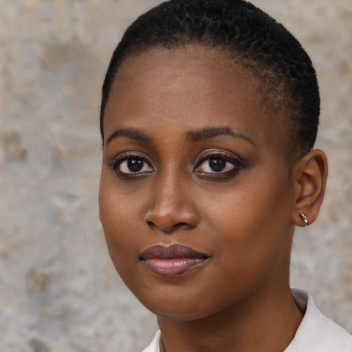 Joyful black young-adult female with short  brown hair and brown eyes