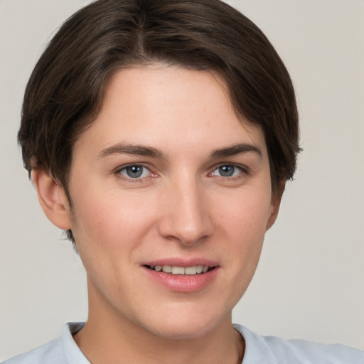 Joyful white young-adult female with short  brown hair and grey eyes