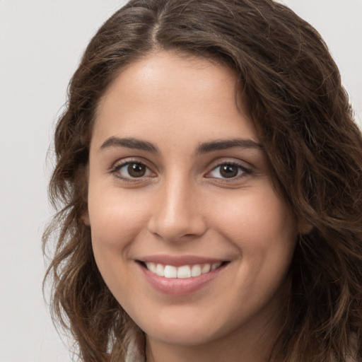 Joyful white young-adult female with long  brown hair and brown eyes