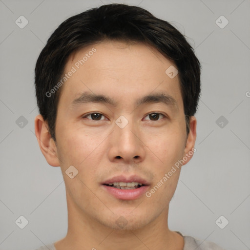 Joyful asian young-adult male with short  brown hair and brown eyes