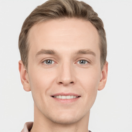 Joyful white young-adult male with short  brown hair and grey eyes