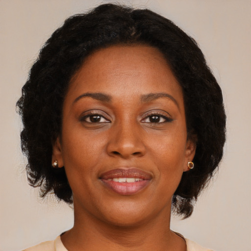 Joyful black adult female with long  brown hair and brown eyes