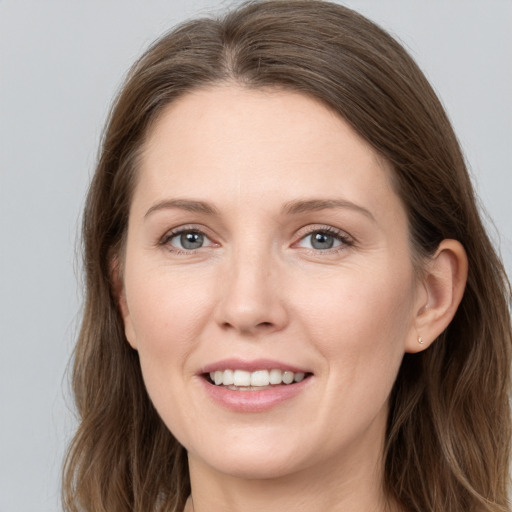 Joyful white young-adult female with long  brown hair and grey eyes