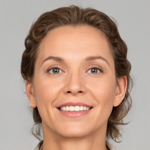 Joyful white adult female with medium  brown hair and grey eyes