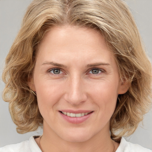 Joyful white young-adult female with medium  brown hair and blue eyes