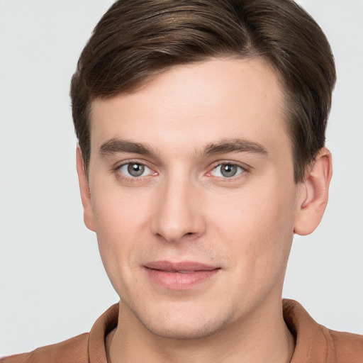 Joyful white young-adult male with short  brown hair and grey eyes