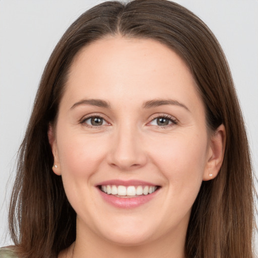 Joyful white young-adult female with long  brown hair and brown eyes