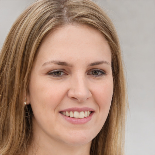 Joyful white young-adult female with long  brown hair and brown eyes