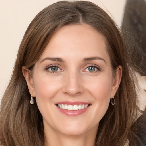 Joyful white young-adult female with long  brown hair and grey eyes