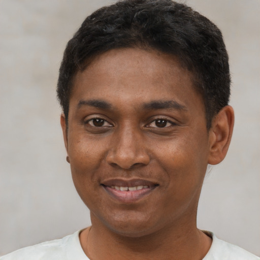 Joyful black young-adult male with short  black hair and brown eyes