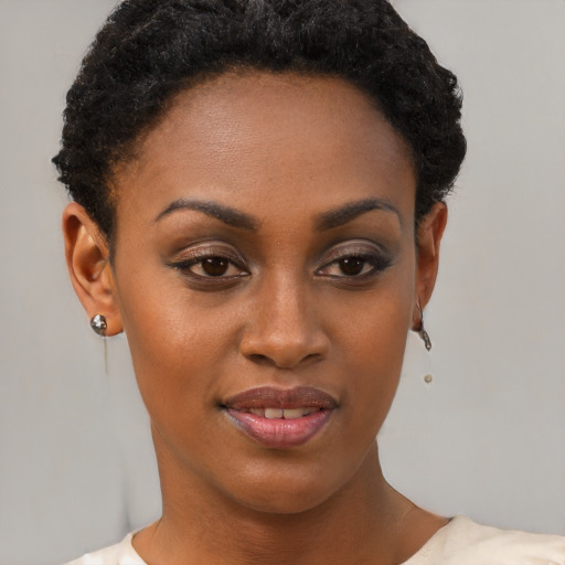 Joyful black young-adult female with short  brown hair and brown eyes