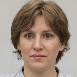 Joyful white adult female with medium  brown hair and grey eyes