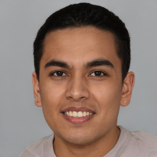 Joyful latino young-adult male with short  black hair and brown eyes