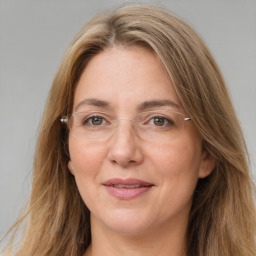 Joyful white adult female with long  brown hair and green eyes