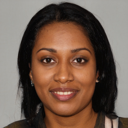 Joyful black young-adult female with long  black hair and brown eyes