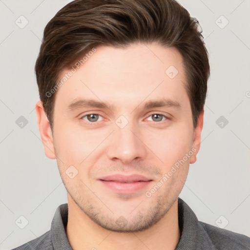 Joyful white young-adult male with short  brown hair and grey eyes