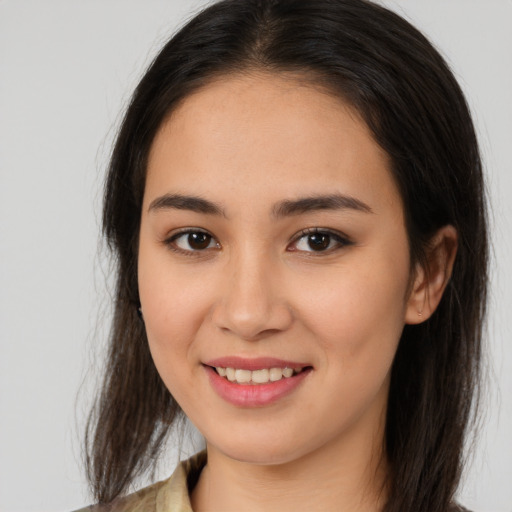 Joyful latino young-adult female with long  brown hair and brown eyes
