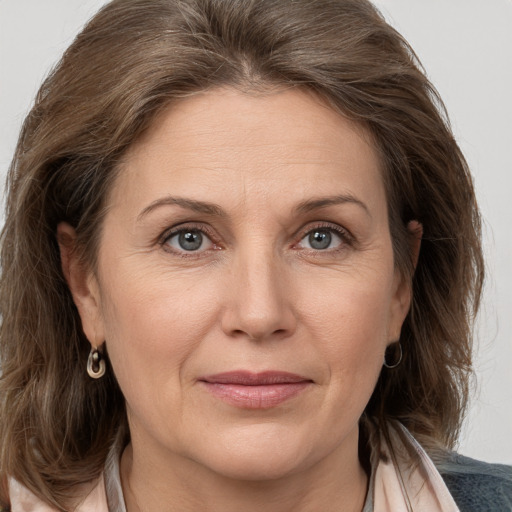 Joyful white adult female with medium  brown hair and grey eyes