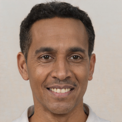 Joyful latino adult male with short  black hair and brown eyes