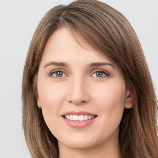 Joyful white young-adult female with long  brown hair and grey eyes