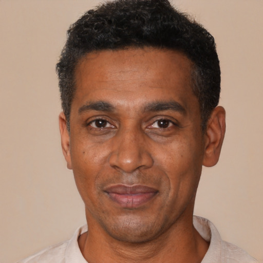 Joyful black adult male with short  black hair and brown eyes