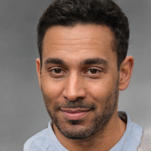 Joyful white young-adult male with short  black hair and brown eyes