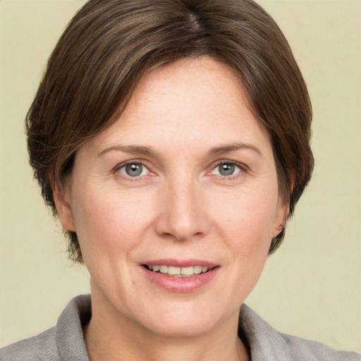 Joyful white adult female with medium  brown hair and grey eyes