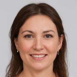 Joyful white young-adult female with long  brown hair and grey eyes