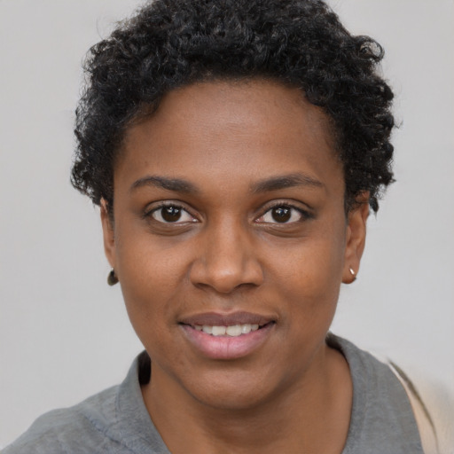 Joyful black young-adult female with short  black hair and brown eyes