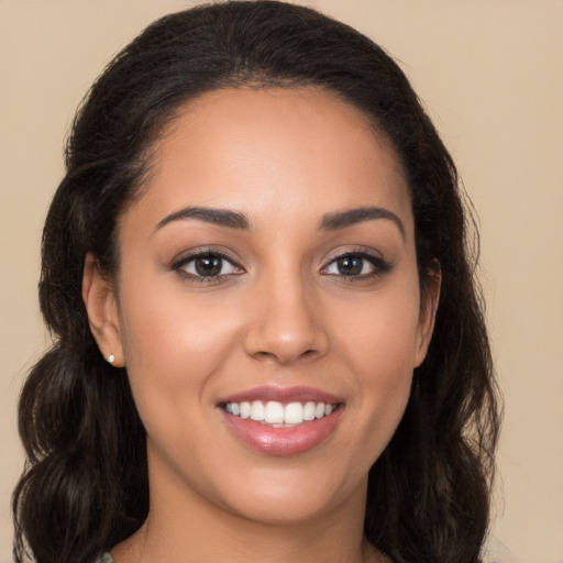 Joyful latino young-adult female with long  brown hair and brown eyes