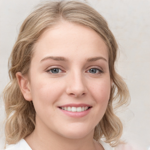 Joyful white young-adult female with medium  brown hair and blue eyes