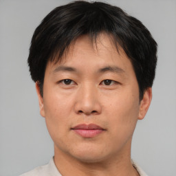 Joyful asian adult male with short  brown hair and brown eyes