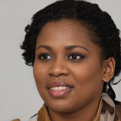 Joyful black young-adult female with long  black hair and brown eyes