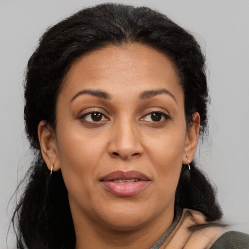 Joyful latino adult female with medium  brown hair and brown eyes