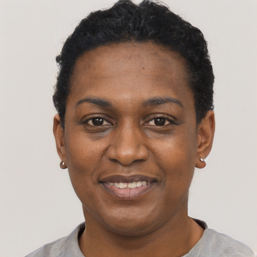 Joyful black young-adult female with short  black hair and brown eyes