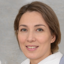 Joyful white adult female with medium  brown hair and green eyes