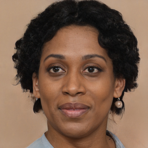 Joyful black adult female with short  black hair and brown eyes