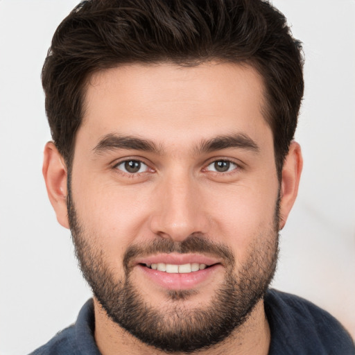 Joyful white young-adult male with short  brown hair and brown eyes