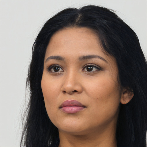 Joyful latino young-adult female with long  black hair and brown eyes