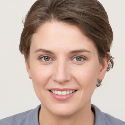 Joyful white young-adult female with short  brown hair and grey eyes