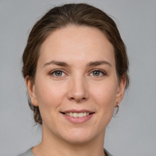 Joyful white young-adult female with medium  brown hair and grey eyes