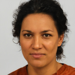 Joyful latino adult female with medium  brown hair and brown eyes